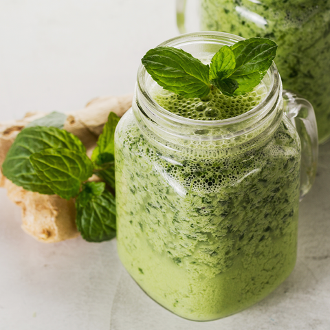 A Jar of Green smoothie with mint leaves topping